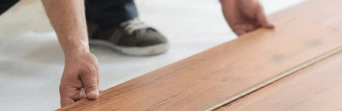 A professional installing laminate flooring in Portland, OR